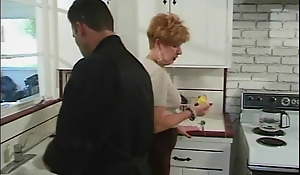 Younger guy gets deepthroated by 70 year old redhead in kitchen